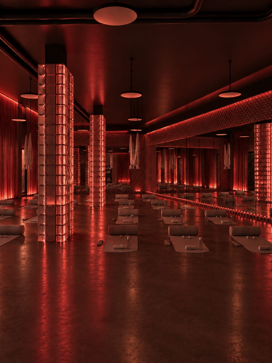 La même salle, plafonniers éteints : seules les colonnes de briques de verre restent allumées en rouge.